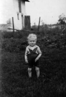 Kazimierz Dors na tle budynku gospodarczego