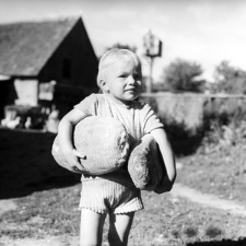 Iwona Baranowska carries loaves of bread from a shop