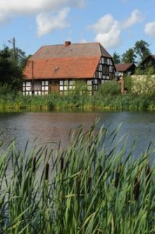 Budynek mieszkalny z zabudowaniami gospodarczym w tle w Bruskowie Wielkim