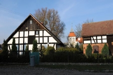 Budynek mieszkalny oraz gospodarczy z kościołem w tle w Swołowie