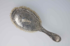 Yellow bristle brush in oval frame with MG monogram